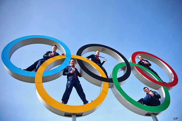 Мужская команда по керлингу из Великобритании фотографируется на фоне олимпийских колец в Олимпийском парке
