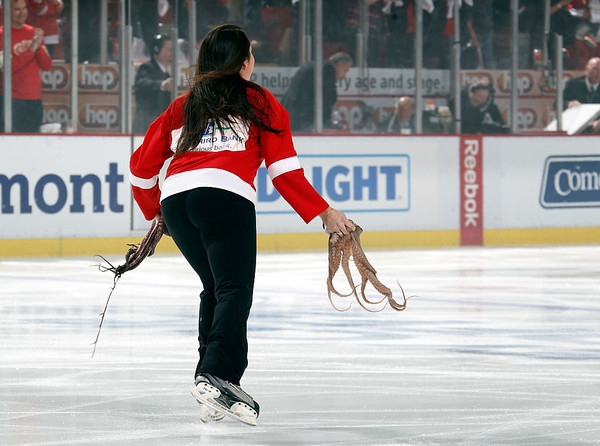 Работница Детройта убирает двух осьминогов со льда
